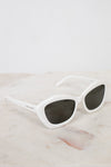 White sunglasses with dark lenses on a marble surface