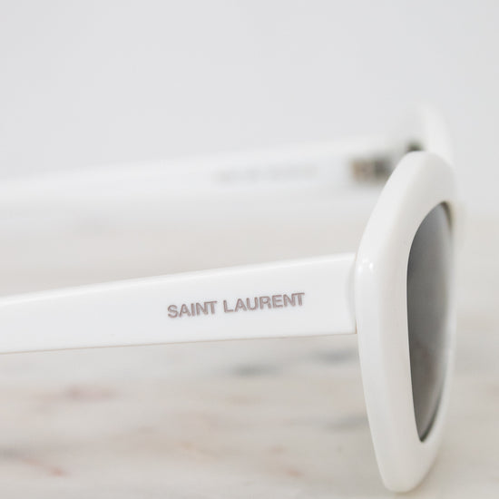 White Saint Laurent sunglasses on a marble surface