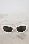 White cat-eye sunglasses on a marble surface