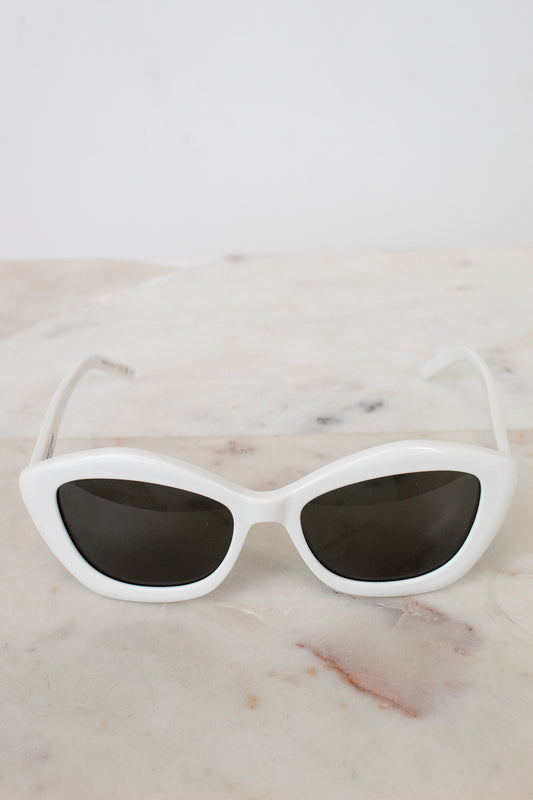 White cat-eye sunglasses on a marble surface