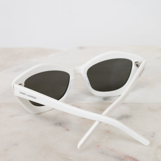 White sunglasses with black lenses on a marble surface