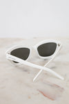 White sunglasses with black lenses on a marble surface