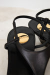 Black sandals with a brand logo on a light background