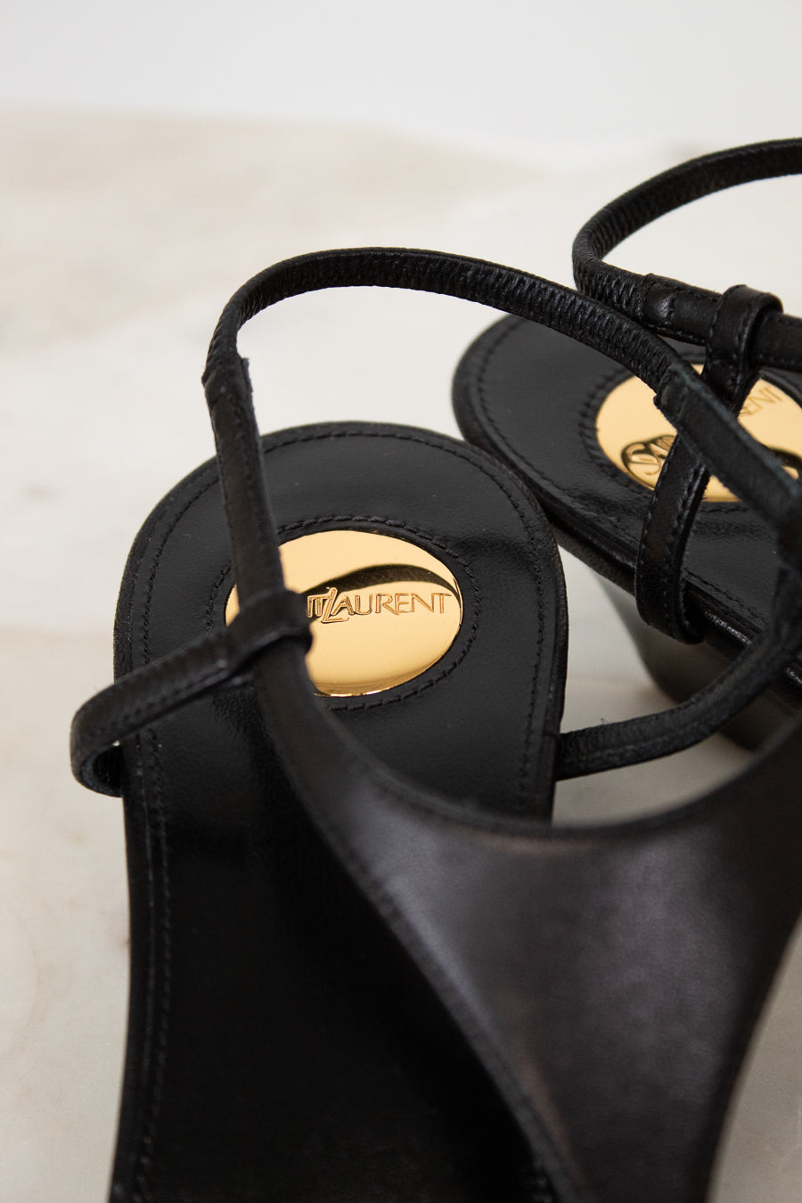 Black sandals with a brand logo on a light background