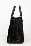 A black crocodile-embossed leather handbag shown from the back, featuring dual top handles and a structured silhouette, set against a plain white background.