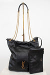 A black leather Saint Laurent shoulder bag with gold-tone chain straps and a matching black leather pouch, displayed on a white background with a stand.
