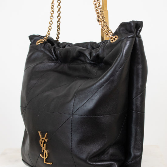 A black leather slouchy shoulder bag with gold-tone chain straps and a gold-tone YSL hardware logo on the front, set against a clean white background.