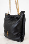 A black leather slouchy shoulder bag with gold-tone chain straps and a gold-tone YSL hardware logo on the front, set against a clean white background.