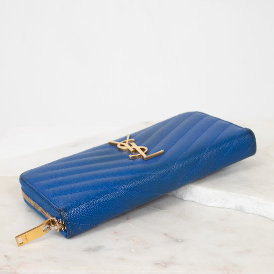 Blue wallet with gold accents on a marble surface