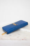 Blue wallet with gold accents on a marble surface