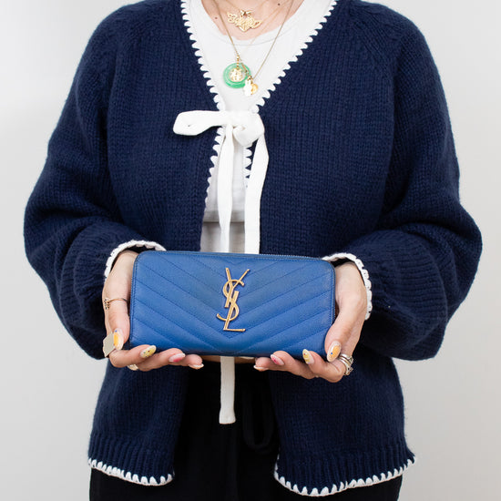 Person holding a blue wallet with a white background