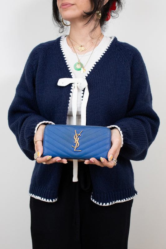 Person holding a blue wallet with a white background