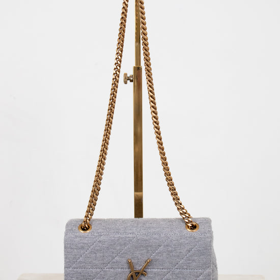Gray quilted YSL handbag with gold chain strap on a white background