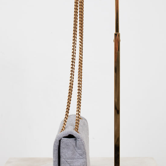 Gray textured handbag with gold chain strap on a white background