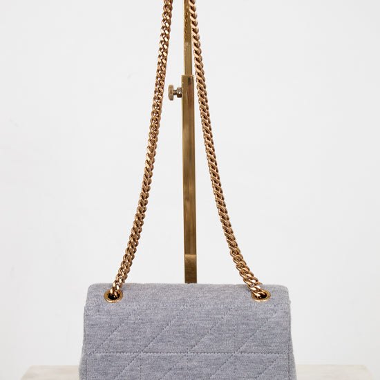 Gray quilted handbag with gold chain strap on a white background