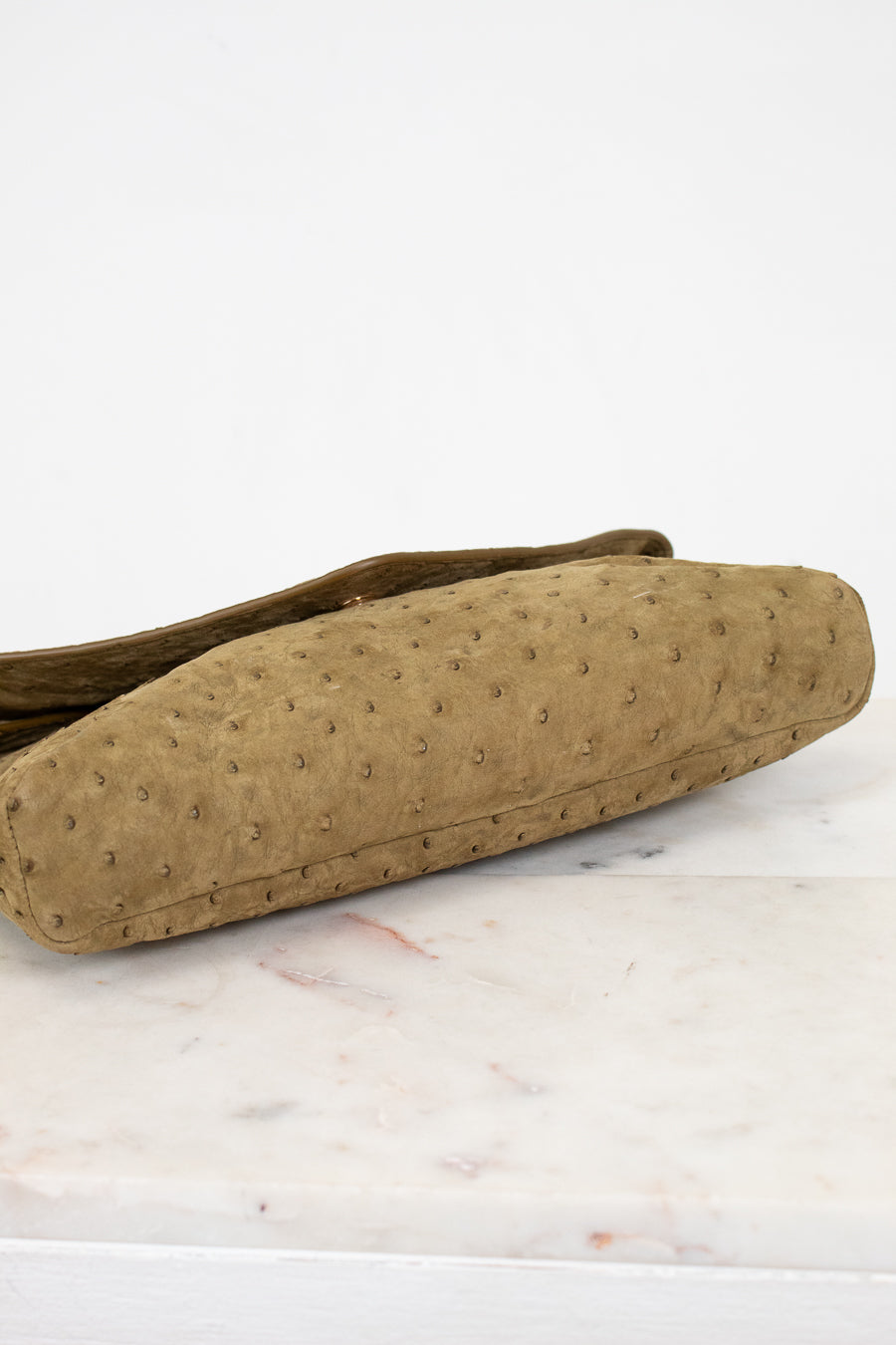 Brown textured bag on a white marble surface