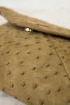Close-up of a brown handbag with a textured surface.