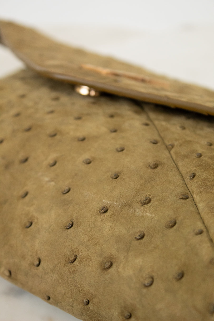 Close-up of a brown handbag with a textured surface.