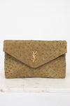 Beige clutch bag with a "YSL" brand logo on a white background