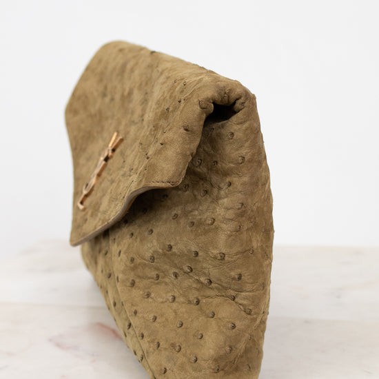 Brown textured clutch bag on a white surface