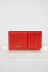Red cardholder with 'Saint Laurent' branding on a white background