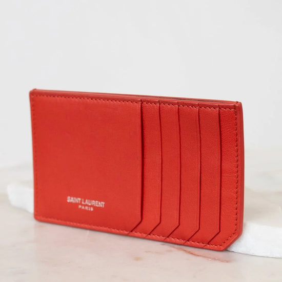 Red cardholder with Saint Laurent logo on a white surface