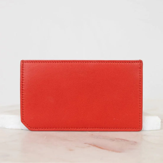Red wallet on a white surface with a light gray background