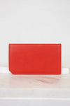 Red wallet on a white surface with a light gray background