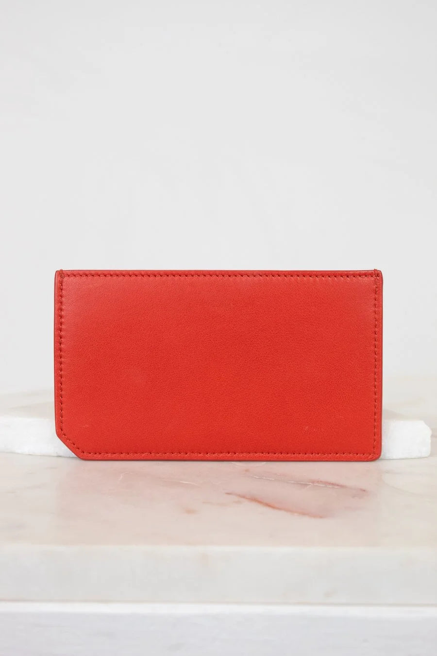 Red wallet on a white surface with a light gray background