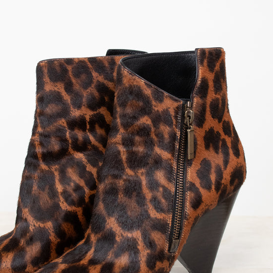 Side view of black and brown leopard print pointed toe ankle boot with conical heel.