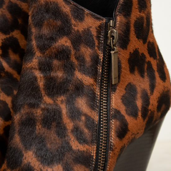 Close-up of a leopard-print ankle boot with a side zipper and block heel, shown against a plain light background.