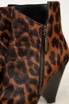 Close-up of a leopard-print ankle boot with a side zipper and block heel, shown against a plain light background.