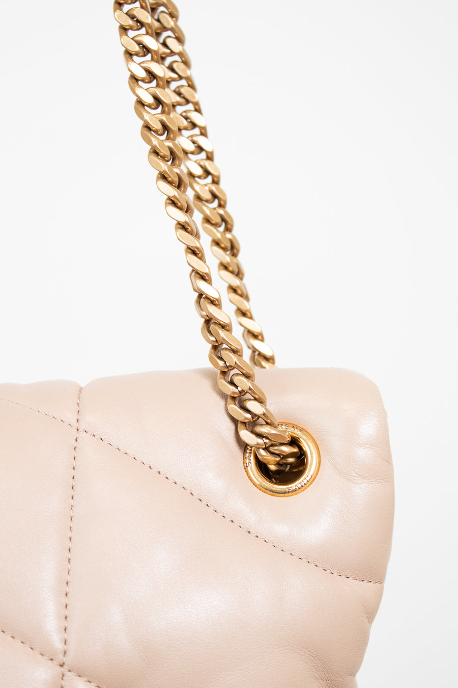 Beige handbag with gold chain on a white background