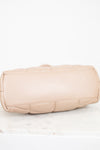 Beige quilted handbag on a white background