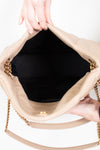 Beige handbag with gold chain handle held open by hands on a white background