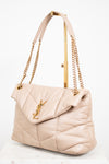 Beige handbag with gold chain and handle on a white background