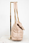 Beige quilted handbag with gold chain strap on a white background