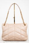 Beige quilted handbag with gold chain straps on a white background