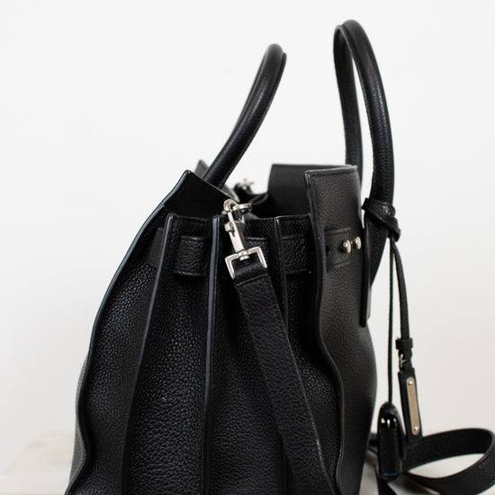 Black leather handbag on a light gray background