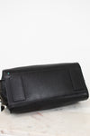 Black leather handbag on a light marble surface