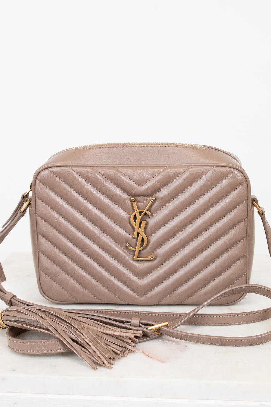 Beige handbag with a brand logo on a white background