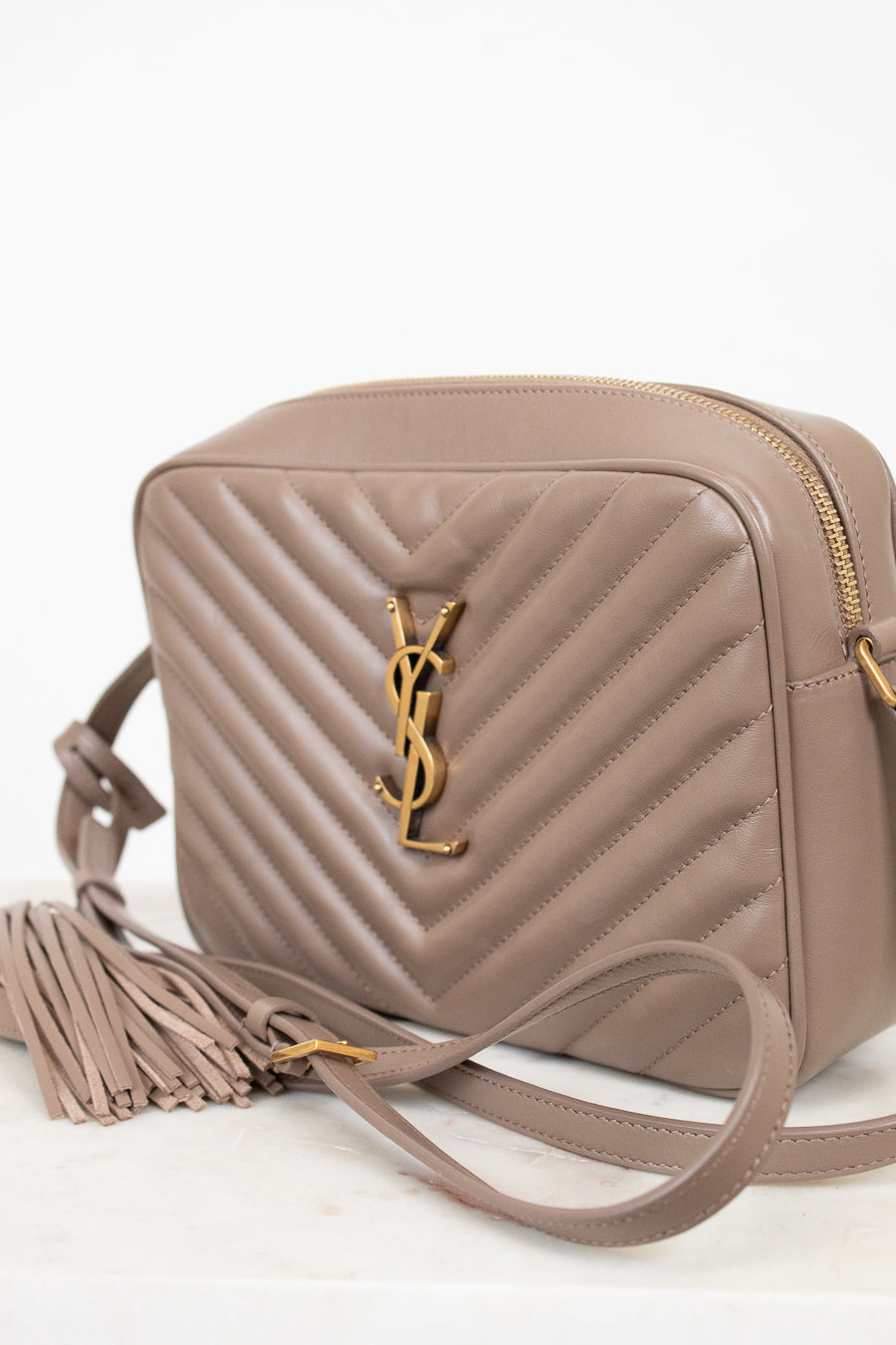 Beige handbag with a brand logo on a white background
