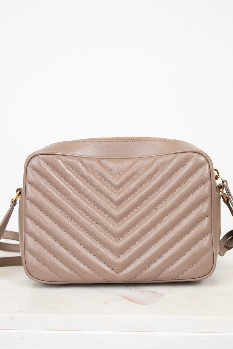 Beige quilted handbag on a white background