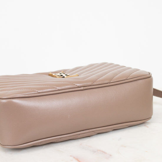 Taupe handbag with a gold clasp on a light pink background