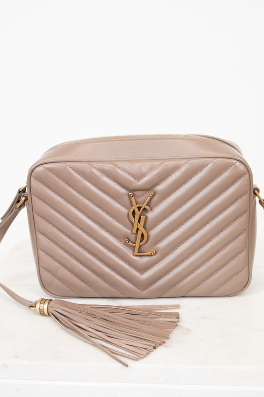 Beige handbag with tassel and brand logo on a white background