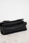 Black leather shoulder bag on a marble surface