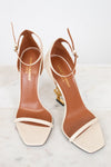 Pair of YSL high-heeled sandals on a light background