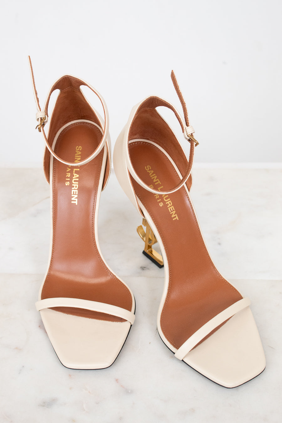 Pair of YSL high-heeled sandals on a light background