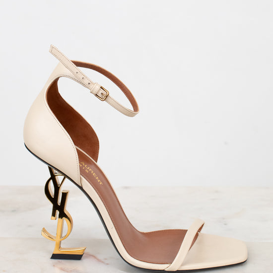 Beige high-heeled sandal with gold accents on a light background