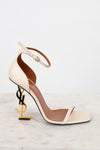 Beige high-heeled sandal with gold accents on a light background